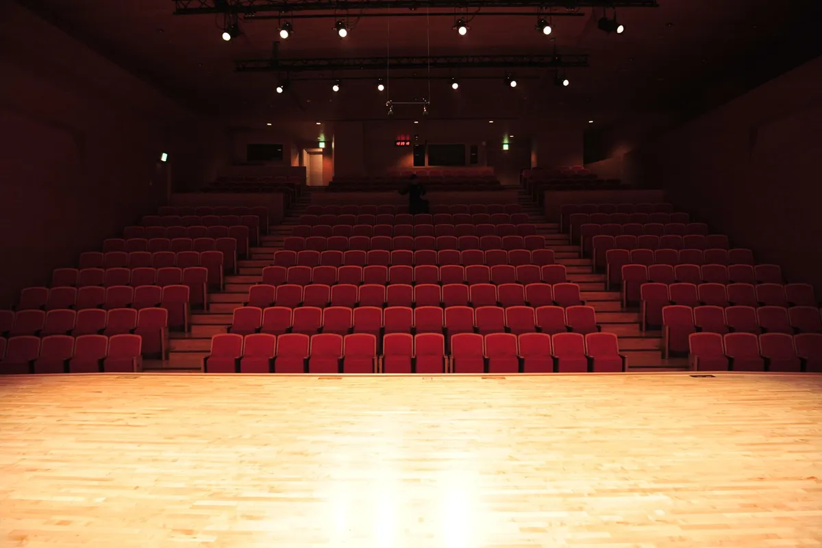 Palco de teatro iluminado visto da plateia