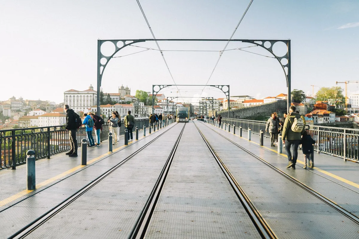 Pedestres atravessam a Ponte Dom Luís I sobre o Douro, no Porto