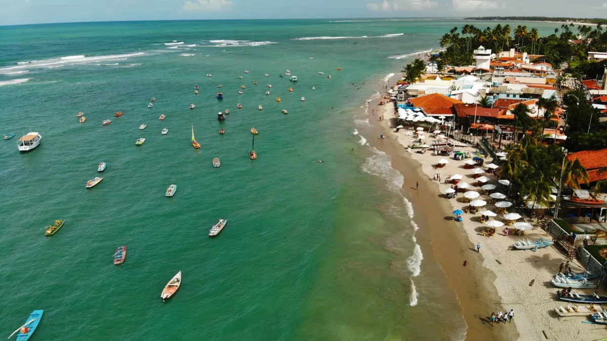 Vista aérea da praia de Porto de Galinhas, Pernambuco, com barcos no mar verde