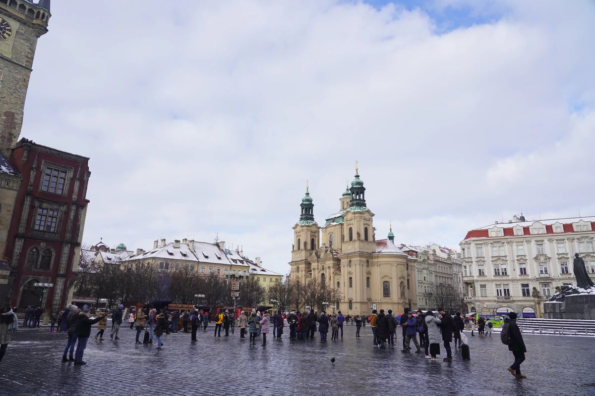 Praça da Cidade Velha de Praga no inverno, com a Igreja de São Nicolau e visitantes