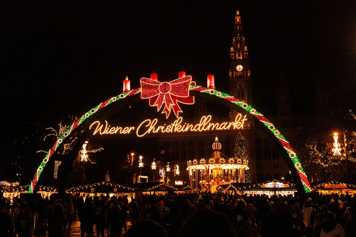 Entrada iluminada do mercado de Natal na Rathausplatz em Viena