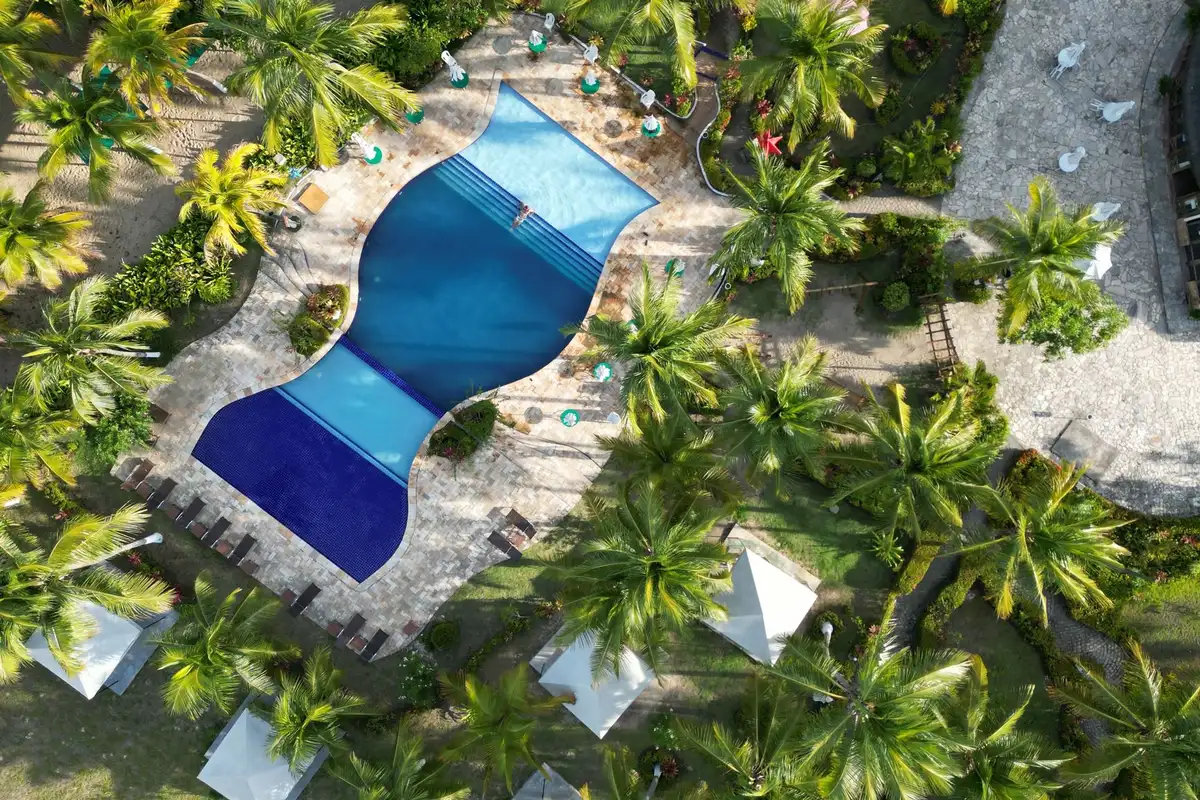 Vista aérea de piscina tropical com palmeiras em Alagoas; foto contextual, sem identificação de resort da lista.