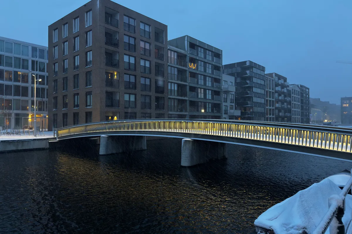 Ponte sobre canal de Amsterdã em noite de inverno com neve