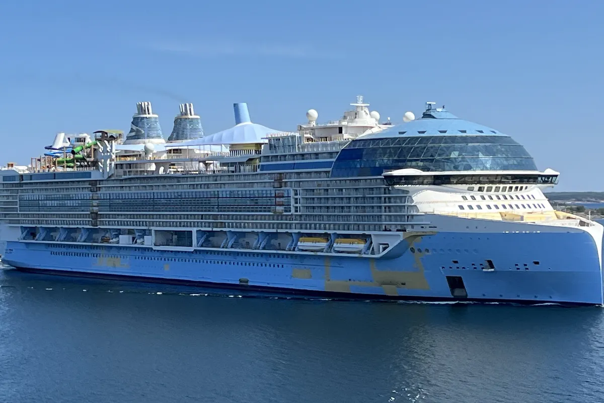 Icon of the Seas visto de lado no mar, com proa e área de piscinas