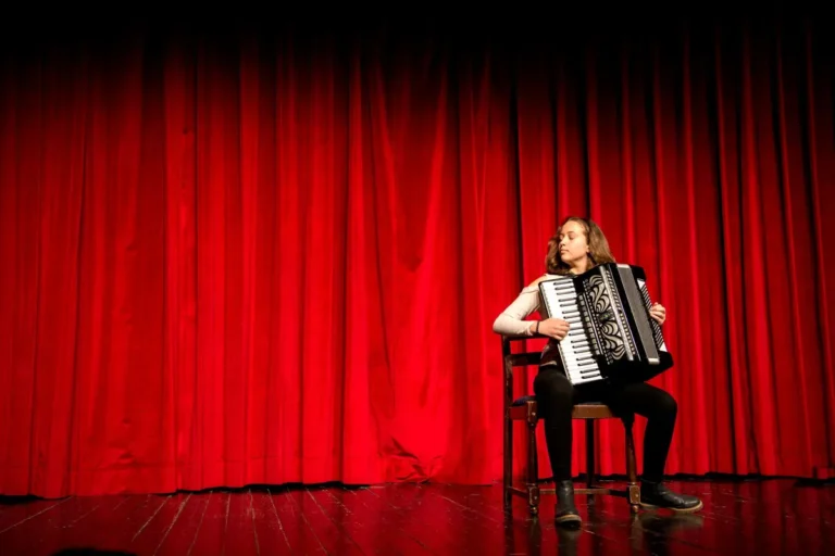 Sanfoneiro tocando em palco iluminado, imagem ilustrativa do clima do Dominguinho em Alto Mar
