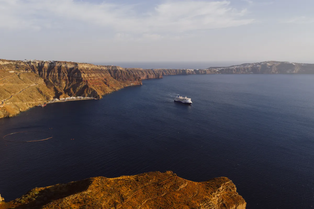 Caldeira de Santorini com falésias e um navio de cruzeiro fundeado