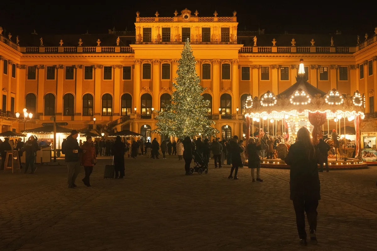 Palácio de Schönbrunn e mercado de Natal iluminados em Viena