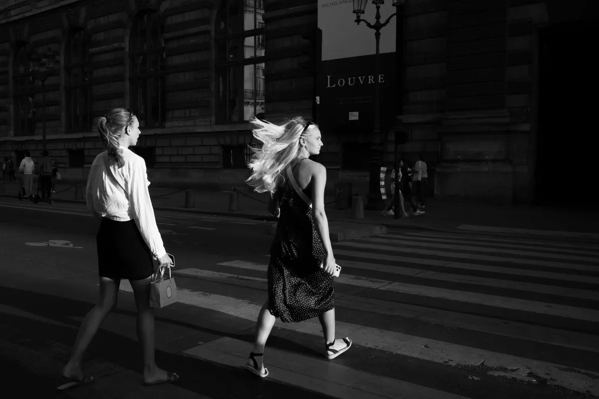 Pedestres atravessando faixa em rua de Paris, França