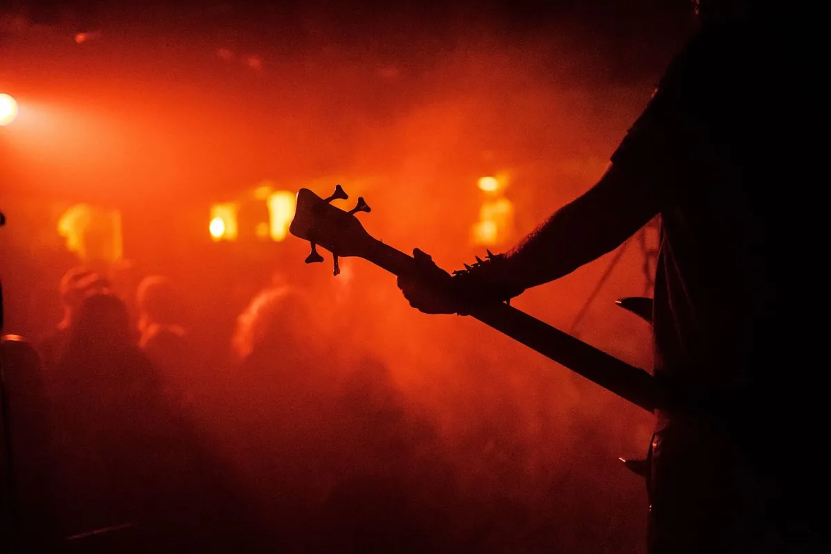 Guitarrista em silhueta no palco durante show de rock