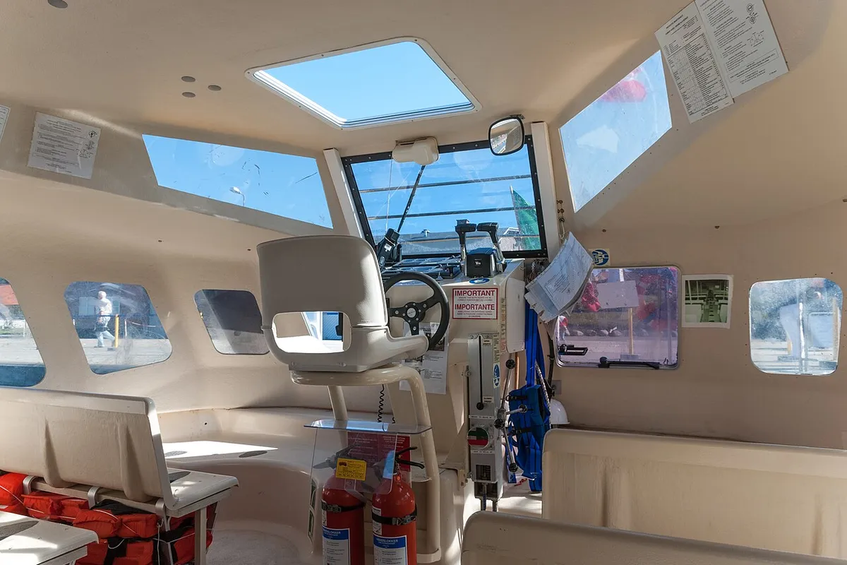 Interior de um tender do navio Costa Magica, com bancos e coletes salva-vidas