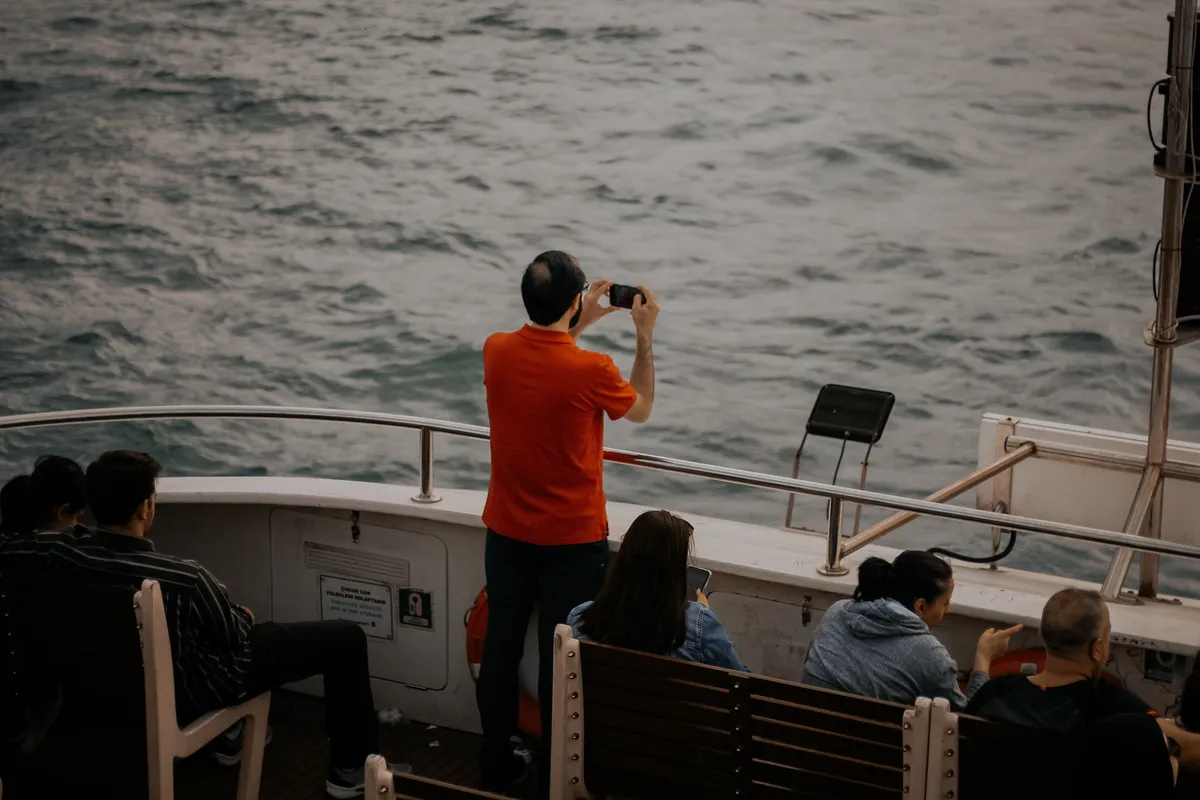 Passageiro filmando o mar com o celular a bordo